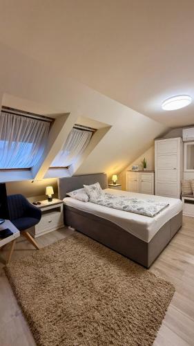 a bedroom with a bed and a desk and a couch at Atkári Vendégház in Bóly