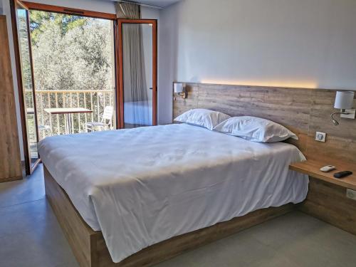 une chambre avec un grand lit et une grande fenêtre dans l'établissement Ustaria, à Peri