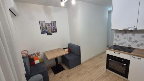 a kitchen with a couch and a table in a room at Apartment Ultra-Central, Parcare, AC, Jaluzele, WiFi in Baia Mare