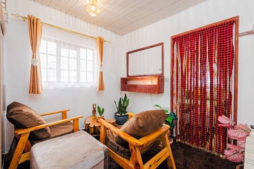 a living room with two chairs and a window at The Kimaru Cottage in Ngong