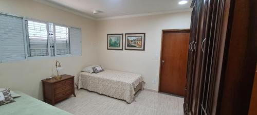 a bedroom with a bed and a dresser and window at Recanto do Nenei in Paraisópolis