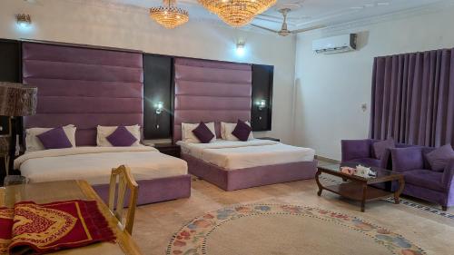 a hotel room with two beds and a couch at Executive Royal Garden in Islamabad