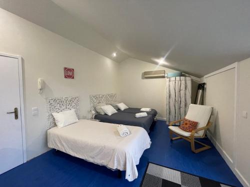 a small room with two beds and a chair at Easy Stay In Espinho in Espinho