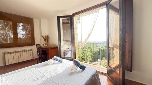 a bedroom with a white bed and a large window at Bellavista in Begur