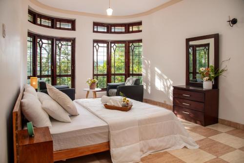 a bedroom with a large bed and a living room at Whispering Trees in Kandy