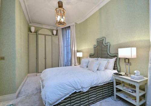 a bedroom with a large bed and a chandelier at Mayfair Green Park Premium Serviced Apartment with 24h Guest Assistance in London