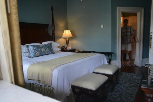 a bedroom with a bed and a man walking into a room at The Marshall House, Historic Inns of Savannah Collection in Savannah