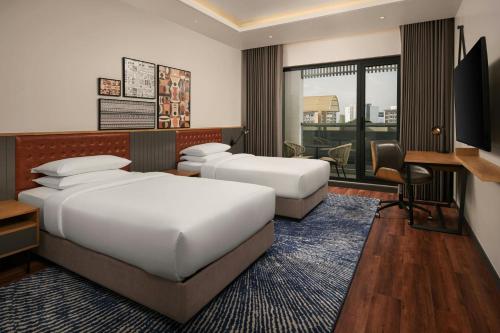 a hotel room with two beds and a desk at Four Points by Sheraton Kinshasa in Kinshasa
