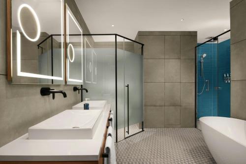 a bathroom with a sink and a shower and a tub at Four Points by Sheraton Kinshasa in Kinshasa