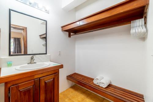 a bathroom with a sink and a mirror at Caribbean Villas Hotel in San Pedro