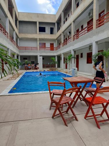 a woman standing in front of a swimming pool at Residencial Ibiapaba in Camocim