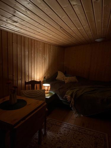 a bedroom with a bed and a table with a lamp at Musekroken in Elverum