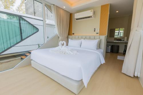 a bedroom with a white bed and a large window at Aqua Soul de Pakbara in Ban Pak Ba Ra