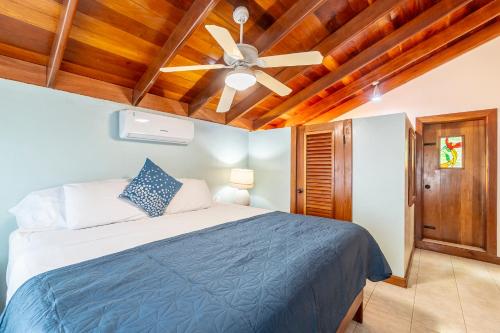 a bedroom with a bed and a ceiling fan at Caribbean Villas Hotel in San Pedro