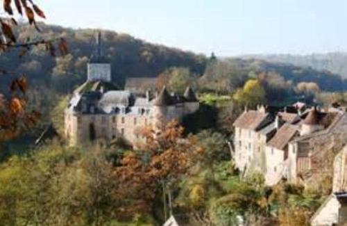 a group of buildings on a hill with trees at Les Fougères Du Lac in Saint-Plantaire