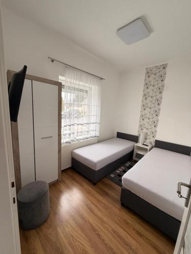 a bedroom with two beds and a window at BE-LE-VALÓ APARTMAN in Szécsény