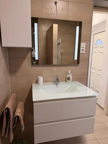 a bathroom with a white sink and a mirror at BE-LE-VALÓ APARTMAN in Szécsény