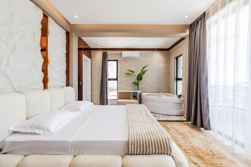 a bedroom with a white bed and a bath tub at Villa Verona in Durrës