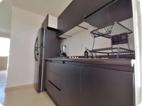 a kitchen with a stainless steel refrigerator and a counter at Depa muy cerca Parques Industriales de El Marqués in Querétaro