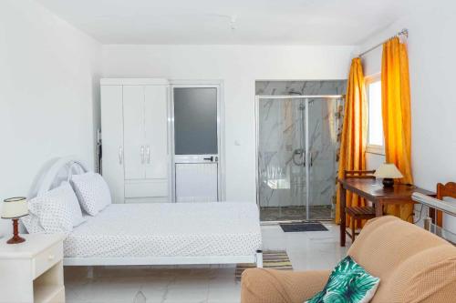 a white living room with a bed and a desk at Hospedaria Santo António 2 in Praia Baixo
