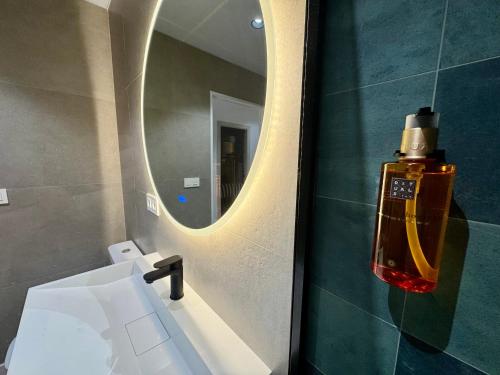 a bathroom with a mirror and a white sink at CAROLINA CENTRO SUITEs in Monesterio