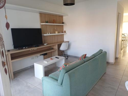 a living room with a couch and a flat screen tv at Duplex De Los Padres in Playa Unión