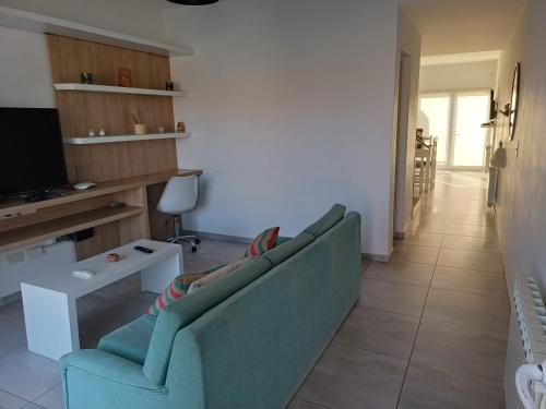 a living room with a couch and a tv at Duplex De Los Padres in Playa Unión