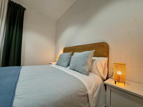 a bedroom with a bed with blue and white pillows at CAROLINA CENTRO SUITEs in Monesterio