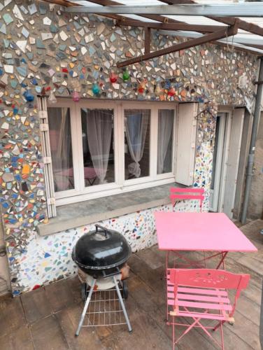 a patio with a grill and a table and chairs at petit studio atypique in Graulhet