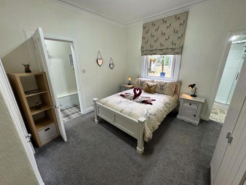 a bedroom with a bed and a window and a mirror at The Sandbed Retreat in Hawick