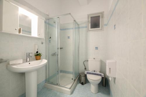 a bathroom with a shower and a sink and a toilet at Angeliki Seaside Hotel in Aliki
