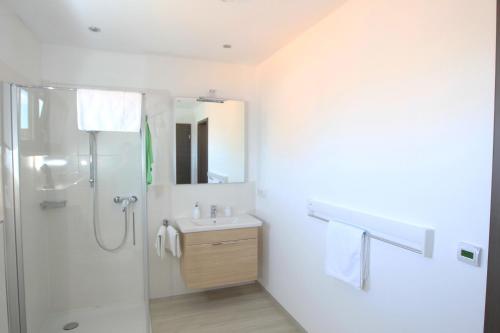een witte badkamer met een douche en een wastafel bij Messewohnung Rehdorf in Oberasbach