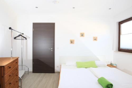 Schlafzimmer mit weißen Wänden, einem Bett und einem Schreibtisch in der Unterkunft Messewohnung Rehdorf in Oberasbach