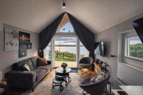 a living room with a couch and a large window at Tiny Haus Auszeit am See in Lathum