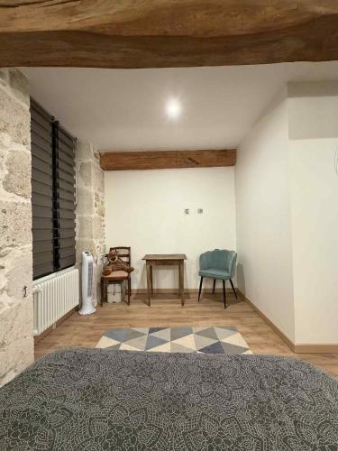 a bedroom with a bed and a table and a chair at Au rêve de Fadi in Bruch