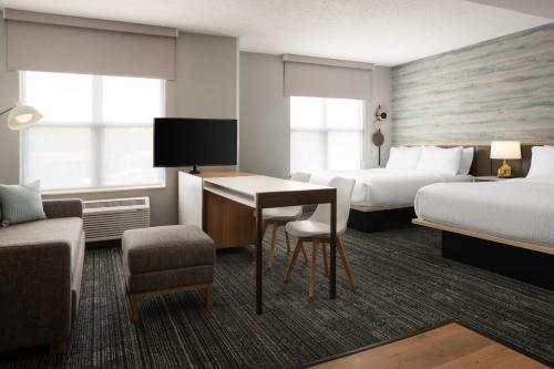 a hotel room with two beds and a desk at TownePlace Suites by Marriott Lafayette in Lafayette