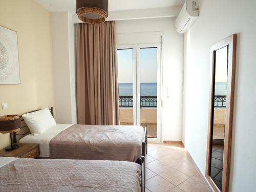 a hotel room with two beds and a view of the ocean at Ostria View in Kardamaina