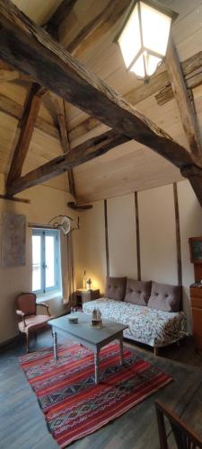 a living room with a couch and a table at L'Escalier des Rêves - Rose in Saint-Sauveur-en-Puisaye