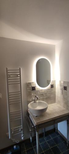 a bathroom with a sink and a mirror at L'Escalier des Rêves - Rose in Saint-Sauveur-en-Puisaye