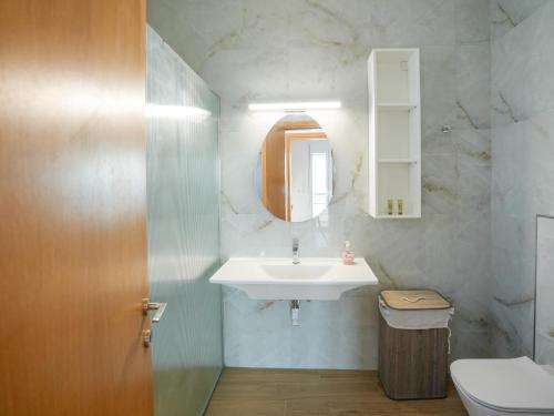 a bathroom with a white sink and a mirror at Ostria View in Kardamaina