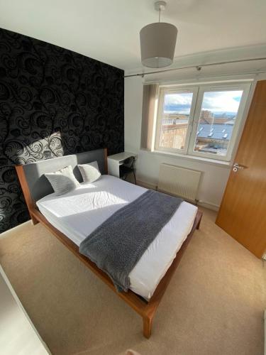 a bedroom with a large bed and a window at One double en-suite room at seaside flat in Aberdeen
