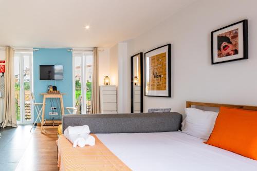 a bedroom with a bed and a living room at Ourique Charm Apartments in Lisbon
