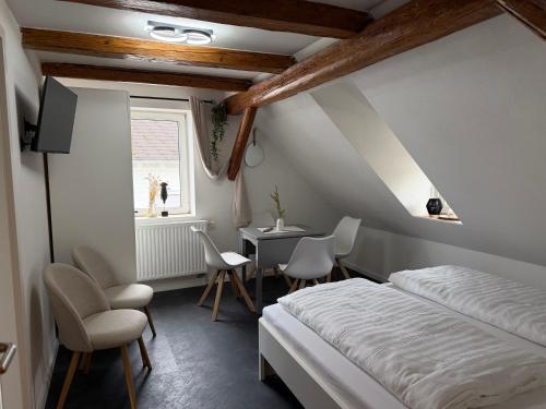 a bedroom with a bed and a desk and chairs at Royans Ferienwohnung in Günzburg