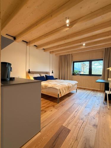 a bedroom with a bed in a room with wooden ceilings at DAS SILO - Neue Ferienwohnungen und Seminarräume, eröffnet März 2026 in Fröndenberg