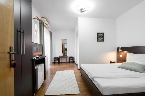 a bedroom with a bed and a flat screen tv at Hotel VULTURUL Pitesti in Piteşti