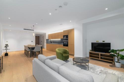 a living room with a white couch and a table at City view 3 bed hotel style apartment, Kings Cross in London