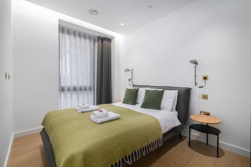 a bedroom with a bed with two towels on it at City view 3 bed hotel style apartment, Kings Cross in London