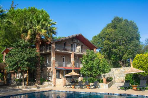 a resort with a pool in front of it at Ballı Butik hotel in Kayakoy