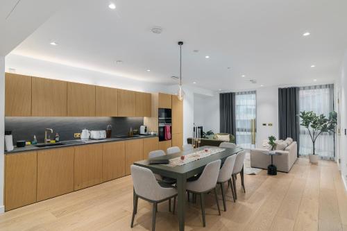 a kitchen and living room with a table and chairs at City view 3 bed hotel style apartment, Kings Cross in London
