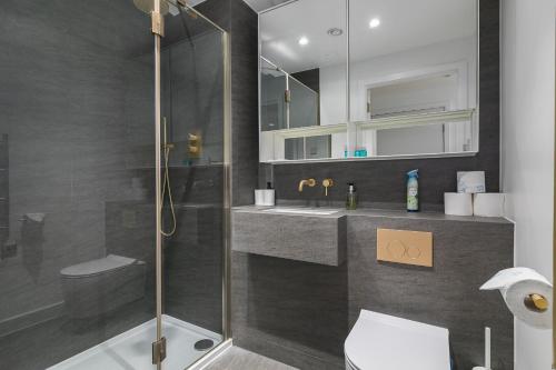 a bathroom with a shower and a toilet and a sink at City view 3 bed hotel style apartment, Kings Cross in London